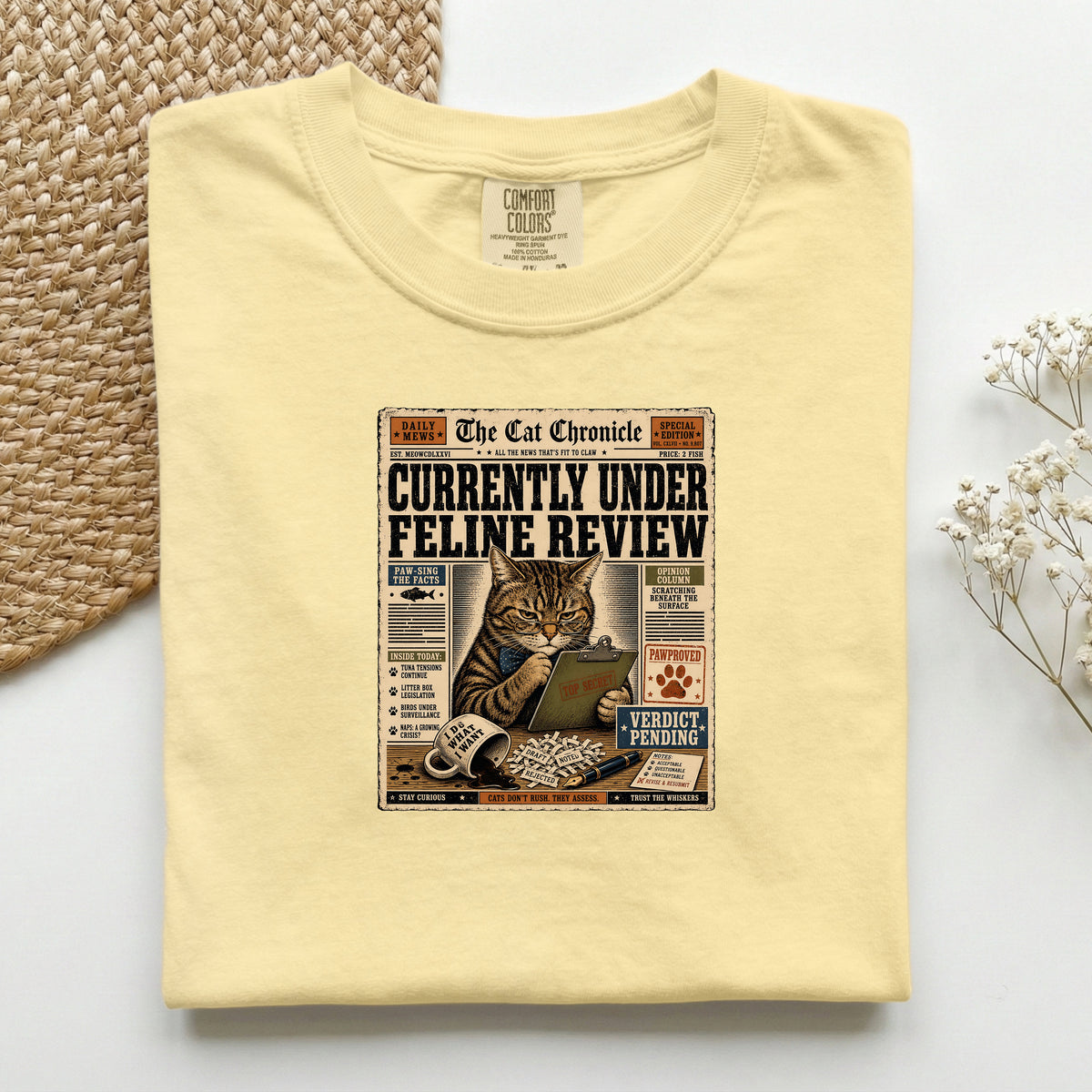 Currently Under Feline Review graphic tee in Butter, folded mockup
