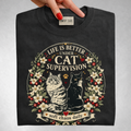 Life Is Better Under Cat Supervision graphic tee in Black, folded flat lay