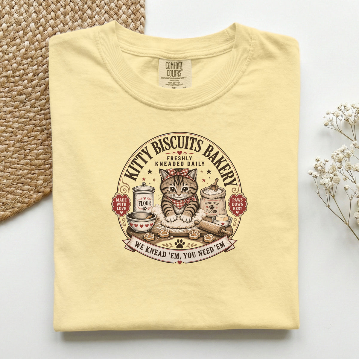 Kitty Biscuits Bakery graphic tee in Butter, folded flat lay