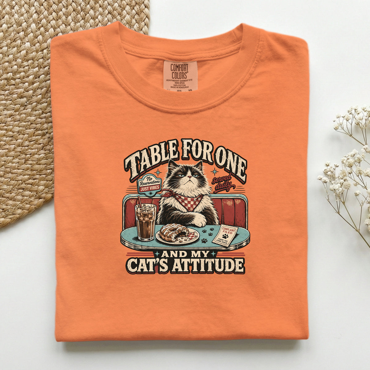 Table For One graphic tee in Burnt Orange, folded flat lay