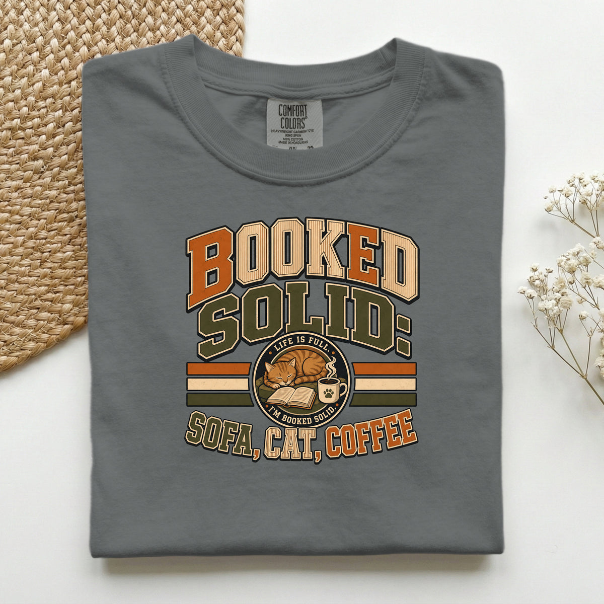 Booked Solid Sofa Cat Coffee graphic tee in Pepper, folded flat lay