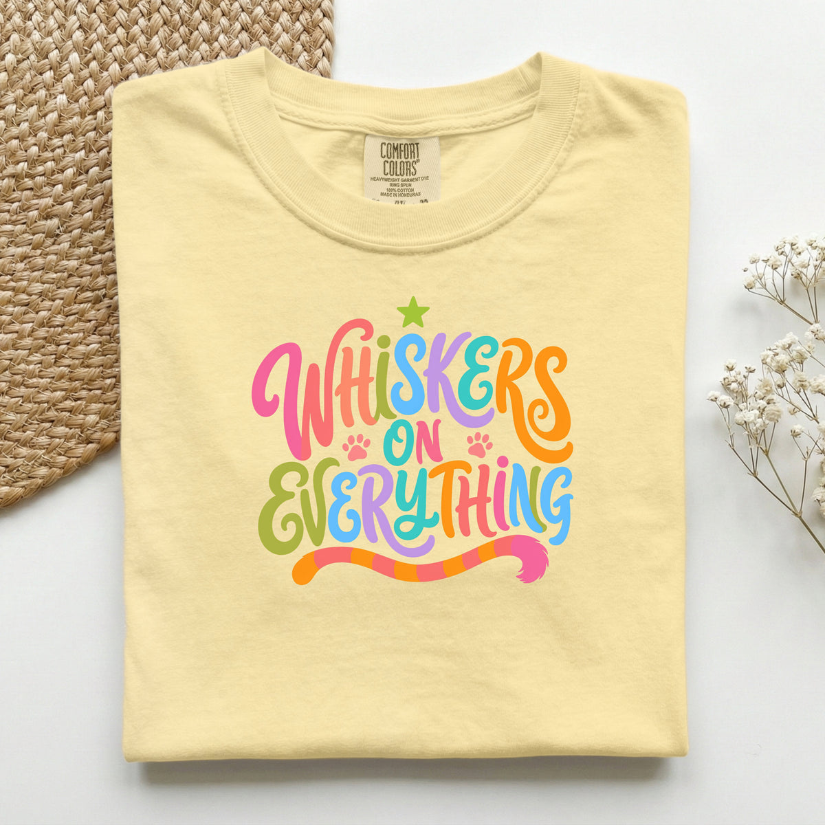 Whiskers On Everything graphic tee in Butter, folded flat lay