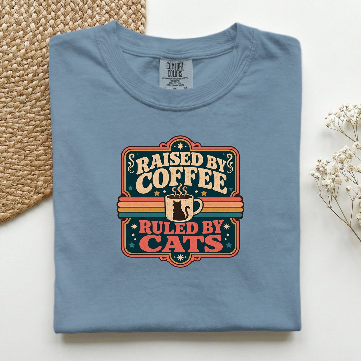 Raised By Coffee Ruled By Cats graphic tee in Blue Jean, folded flat lay