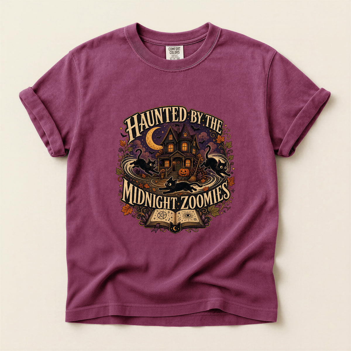 Haunted By The Midnight Zoomies graphic tee in Berry, folded flat lay